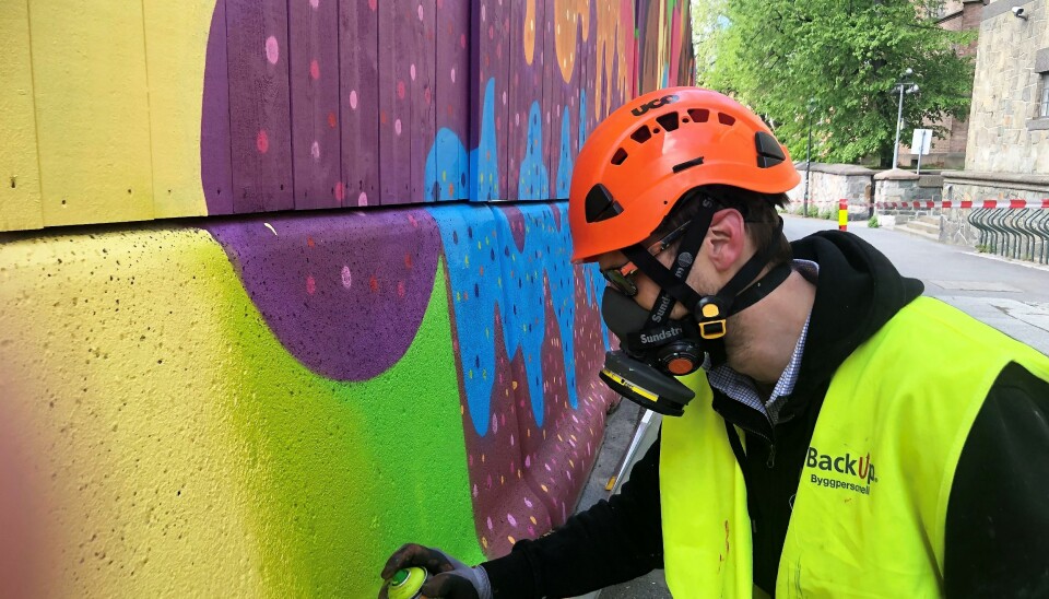Espen Henningsen fargelegger regjeringskvartalet med en sprayboks.