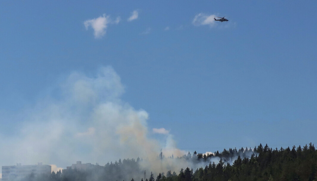 Et politihelikopter svever over stedet der det brenner i terrenget langs en høyspentledning ved Romsås. Foto: Paul Kleiven / NTB Et politihelikopter svever over stedet der det brenner i terrenget langs en høyspentledning ved Romsås. Foto: Paul Kleiven / NTB