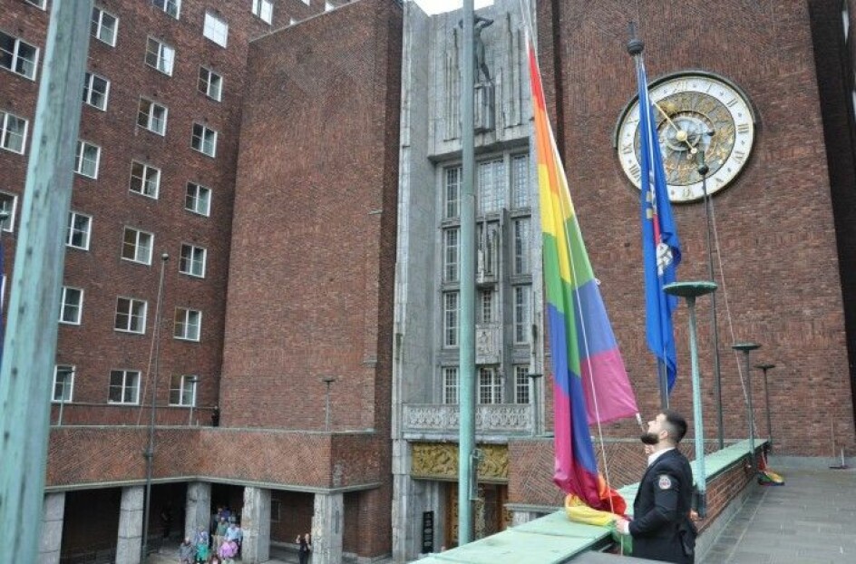 En av rådhusvaktene heiste ett av mange Pride-flagg i 2019. Nå skal regnbueflaggene pryde Rådhuset dobbelt så lenge.