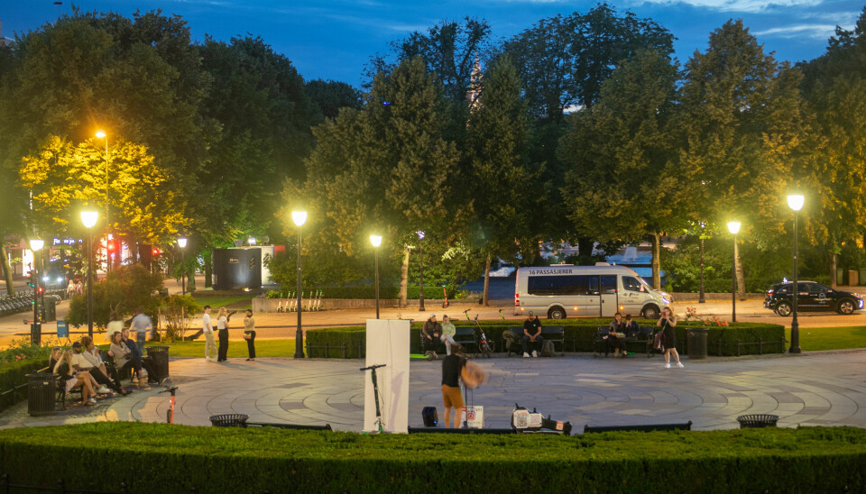 Eidsvolls plass natt til lørdag. Oslo har åpent etter midnatt og en mann spiller musikk foran Stortinget. Foto: Annika Byrde / NTB
