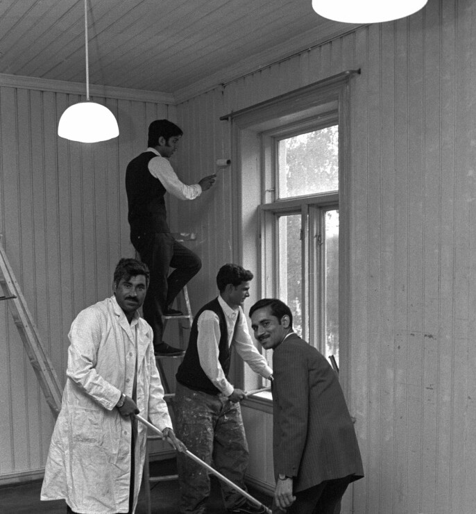 Dette bildet er datert 18. juli 1971, og viser arbeidsinnvandrere fra Pakistan som har hatt midlertidig bosted på Møllergata skole. På bildet er noen av dem kommet til den gamle gardekassernen i Kirkeveien 23 hvor de de maler og vasker et rom før innflytting. Foto: NTB