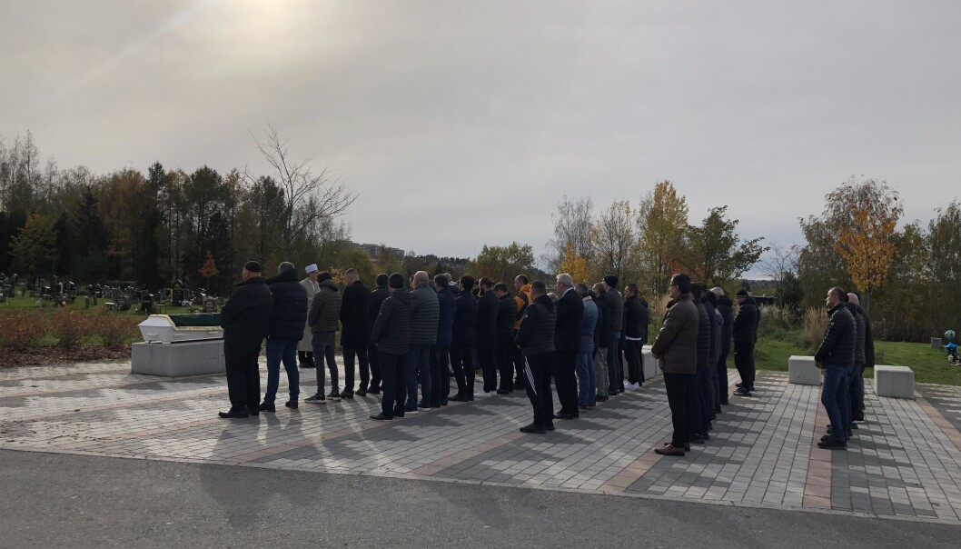 Etter at kista er båret på plass på en granittstein, stiller mennene seg opp, pent på rekke, flere rader etter hverandre.