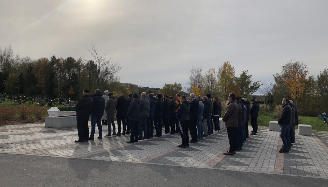 Etter at kista er båret på plass på en granittstein, stiller mennene seg opp, pent på rekke, flere rader etter hverandre. Etter at kista er båret på plass på en granittstein, stiller mennene seg opp, pent på rekke, flere rader etter hverandre.