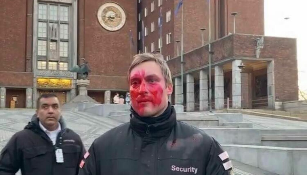Bildet viser tydelig at mannen har blitt sprayet med rødfarge i ansiktet.