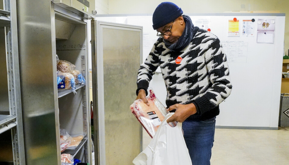 Aden Abdukadir, ved Frelsesarmeens distribusjonslager på Grünerløkka i Oslo, pakker poser med julemiddag til dem som trenger det.
