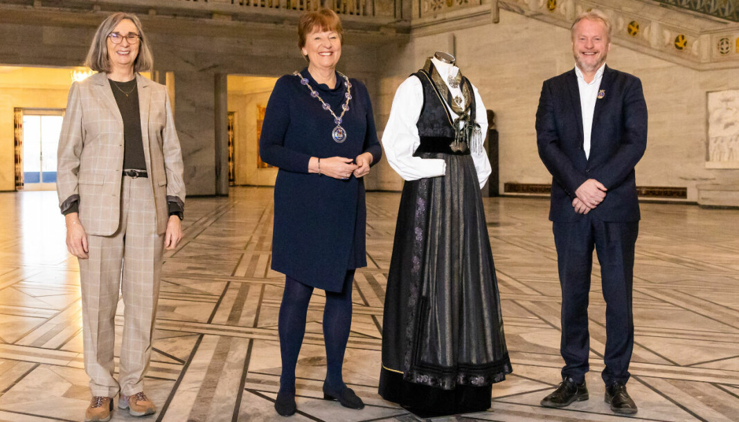 Ordfører Marianne Borgen og byrådsleder Raymond Johansen gir Oslos jubileumsdrakt til prinsessen på 18-årsdagen. Designer Eva Lie til venstre.