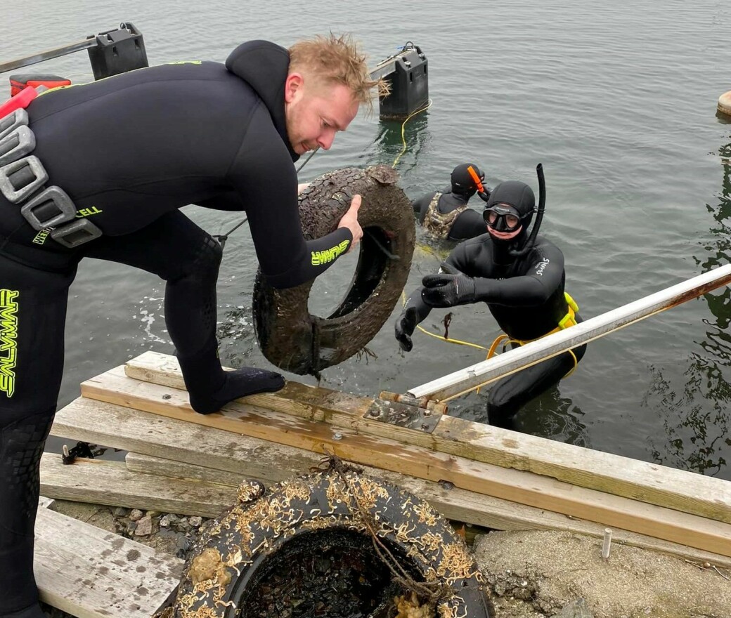 Benjamin Barth trekker opp et dekk som dykkerne fant på fjordbunnen ved Malmøybroa på søndag.