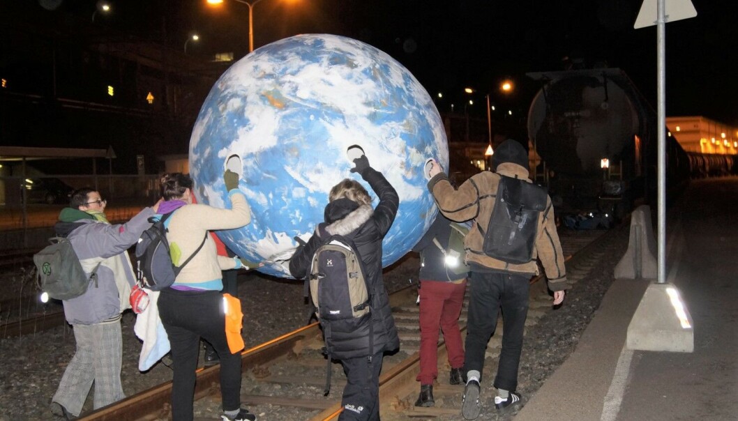 Her bærer Extinction Rebellion inn kloden sin på Oslo Havns anlegg på Sjursøya. I bakgrunnen sees toget med flybensin. Her bærer Extinction Rebellion inn kloden sin på Oslo Havns anlegg på Sjursøya. I bakgrunnen sees toget med flybensin.