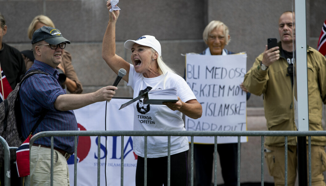 Fanny Bråten fra SIAN krenker Koranen på Eidsvolls plass foran Stortinget. Med mikrofonen i hånda står Max Hermansen. Til høyre står SIAN-leder Lars Thorsen.