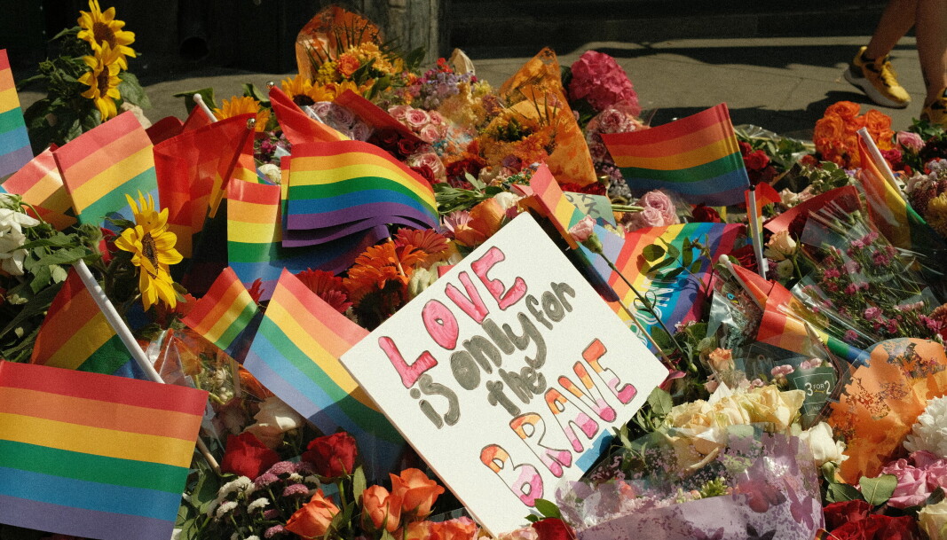 «Love is only for the brave» står det på en av plakatene i blomsterhavet.