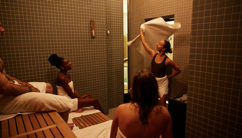 Badstumester Maren Haga svinger håndkleet til glede for gjestene i den nye badstuen.