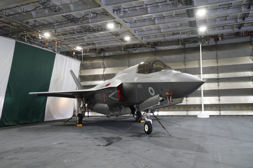 ET F-35B Lightning i hangaren om bord på hangarskipet HMS Queen Elizabeth som er på flåtebesøk i Oslo. Resten av flyflåten om bord er bak den lukkede stålporten. ET F-35B Lightning i hangaren om bord på hangarskipet HMS Queen Elizabeth som er på flåtebesøk i Oslo. Resten av flyflåten om bord er bak den lukkede stålporten.