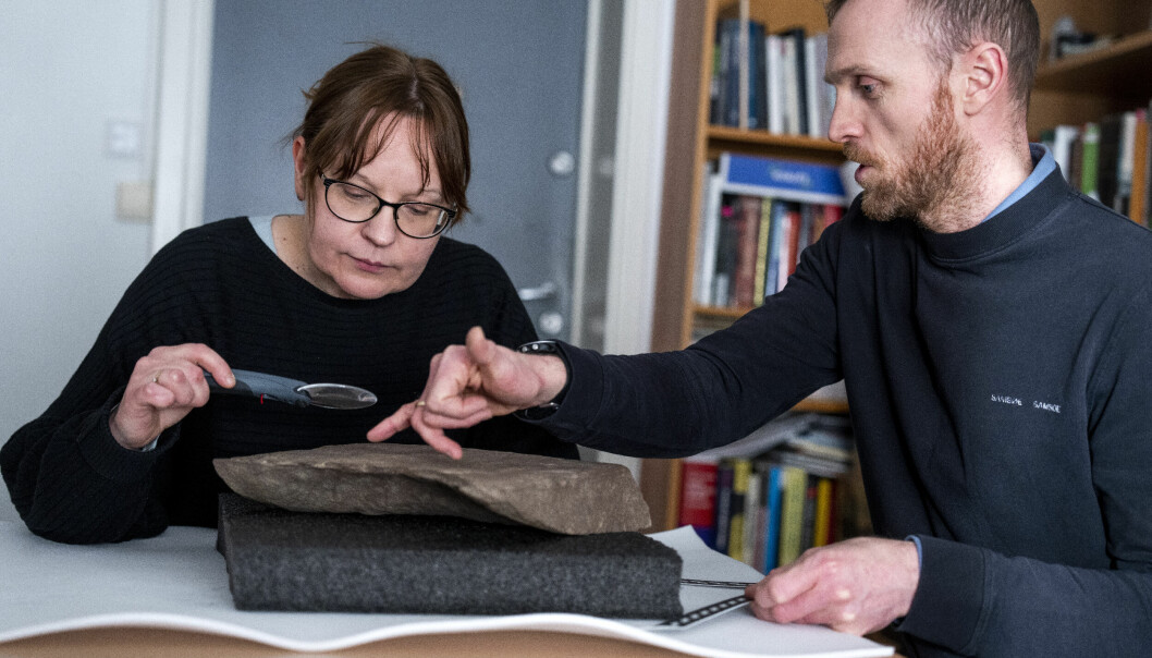 Arkeolog og utgravingsleder Steinar Solheim og Kristel Zilmer, professor i skriftkultur og ikonografi ved Kulturhistorisk museum, studerer den fantastiske runesteinen.
