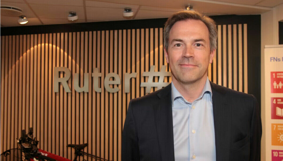 Tidligere styreleder i Ruter - Sigurd Grytten. Står foran et skilt med Ruters logo