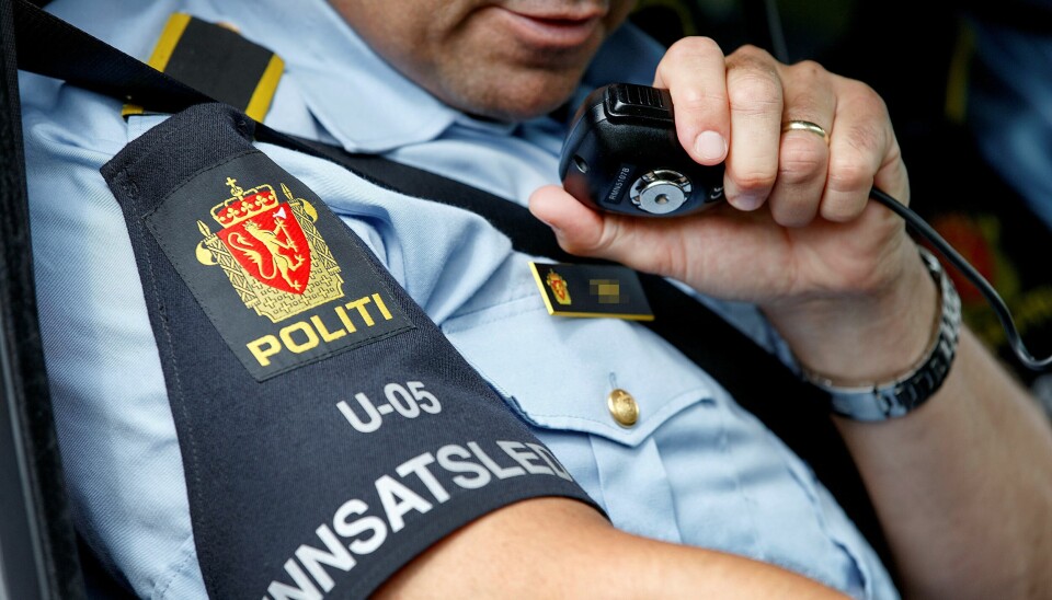 Innsatsleder i politiet snakker over radiosamband mens han sitter i bil. Modellklarert.