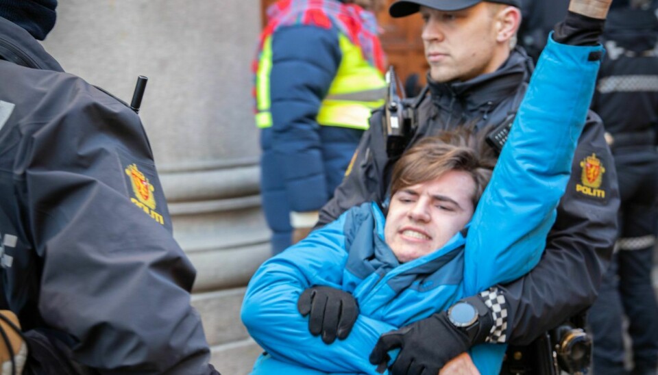 En demonstrant blir bært bort av politiet.