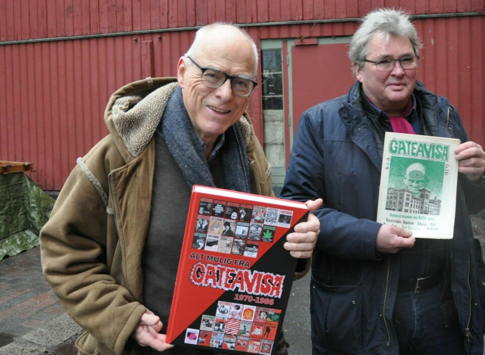 Audun Engh (til v.) og Ulrik Hegnar poserer foran det røde trehuset i Hjelms gate med boka som rommer alle artikler i Gateavisa fra årene 1970 til 1986.