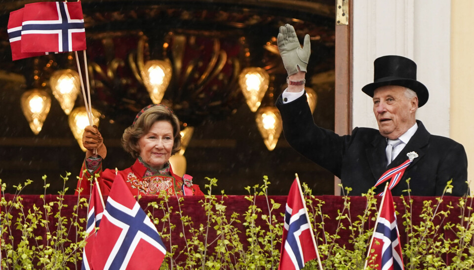Oslo 20210517. Kong Harald og dronning Sonja hilser til folket fra balkongen på Slottet under 17. mai feiring på Slottsplassen i Oslo. På grunn av koronapandemien er det i år en annerledes feiring av nasjonaldagen.Foto: Lise Åserud / POOL / NTB