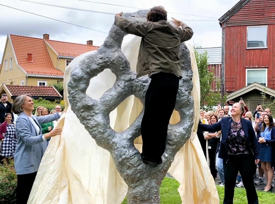 Sigve Knutson klatrer i skulpturen sin under avdukingen på Nic Waals institutt.