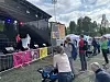Folk følger med på politisk duell mellom ordførerkandidatene på Mortensrud Festival. På scenen står Aps Rina Mariann Hansen og Høyres Anne Lindboe.