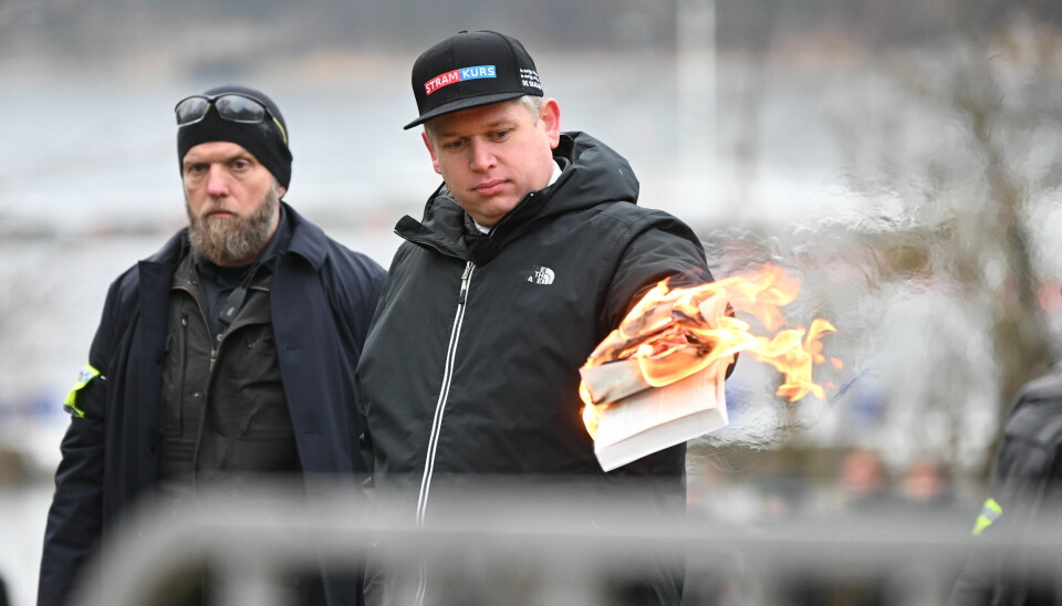 STOCKHOLM, SVERIGE 20230121. Den høyreextreme politikeren Rasmus Paludan brenner et eksemplar av den muslimske hellige boken, Koranen, mens han holder en offentlig demonstrasjon i nærheten av den tyrkiske ambassaden lørdag.Foto: Fredrik Sandberg/TT / NTB