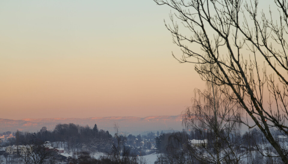 Hvalstad 20240106. Oslo ligger i bakgrunnen og er dekket med et «lokk» med kald luft og noe dis, sett fra Hvalstad i Asker lørdag ettermiddag mens solen var på vei ned.