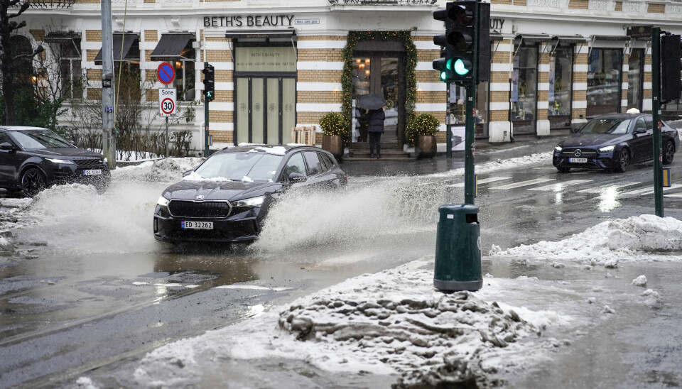Oslo 20240216. Vann spruter fra biler i krysset Frognerveien og Niels Juels gate. Mye overvann på grunn av mildvær og mye snø som smelter.