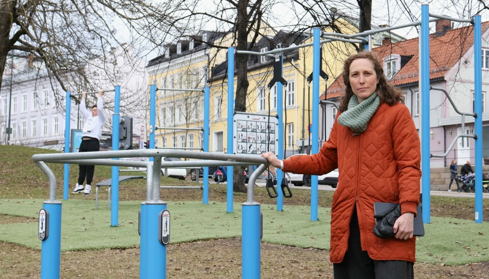 Kvinne, ca 35 står foran en tuftepark som er anlagt i Galgebarg park. Apparatene er blå og det ligger grønne kunstgressmatter under. Hun er alvorlig i ansiktsuttrykket.