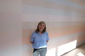 Marianne Brekke står for akrylmaling på en 47 meter lang vegg innendørs. – Fargene representerer lyset barna opplever ute, fra tidlig om morgenen til utpå ettermiddagen, sier Brekke. 